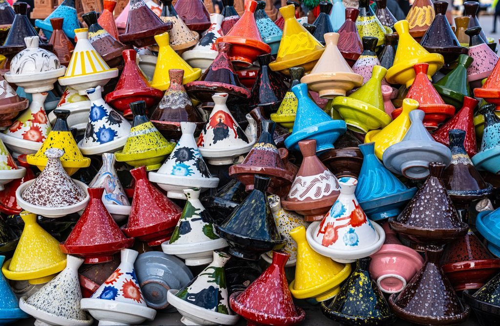 Stacks of colorful glazed tagine pots on a market stall in Marrakesh