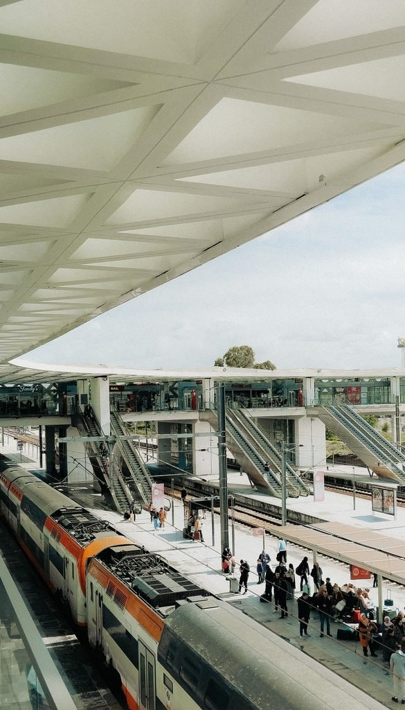 Rabat railway station platform in Morocco with an orange and white train under a latticed roof